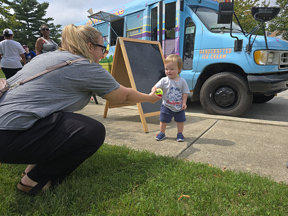 Griffin Noe takes a ball from his mom, Olivia Boehm, left, during the grand opening of Highlands Courts on Sunday, Aug. 17. (Eric Crump/H-F Chronicle)