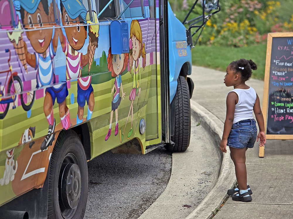 Cailyn Knight-Westbrook admires the artwork on the Dip 'n' Double ice cream truck during the grand opening of Highlands Park Courts on Sunday, July 17. (Eric Crump/H-F Chronicle)
