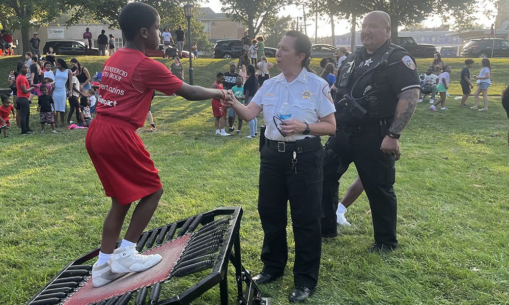 Homewood Police Chief Denise McGrath shakes hands with a Jessie White Tumbler performer at National Night Out. (Nick Ulanowski / H-F Chronicle)