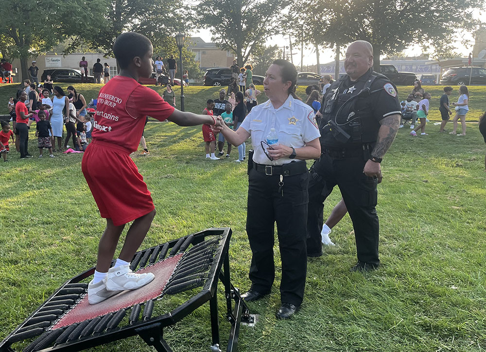 Homewood Police Chief Denise McGrath shakes hands with a Jessie White Tumbler performer at National Night Out. (Nick Ulanowski / H-F Chronicle)