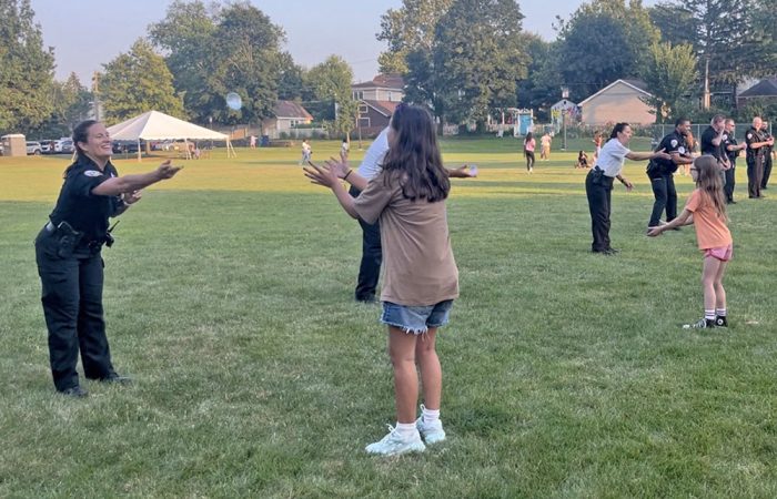 Homewood Deputy Police Chief Kelly Strayer plays a game of water balloon toss with local youth. (Nick Ulanowski / H-F Chronicle)