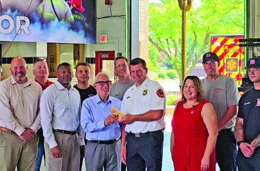 Homewood Mayor Rich Hofeld and Deputy Fire Chief Steve DeJong hold the Outstanding Community Safety Partnership Award presented to the Homewood Fire Department by Erica Fischer, director of training, outreach and partnerships with Transportation Community Awareness and Emergency Response. Village, fire department and CN Railway officials look on. Fischer presented the award at the Homewood Fire Department on June 27. (Eric Crump/H-F Chronicle)