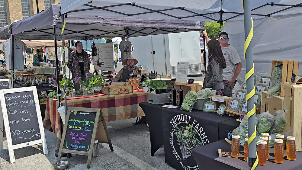 From left, regular Homewood Farmers Market vendors Wrought Iron Farm and Taproot Farms, at the market on Aug. 23. (Eric Crump/H-F Chronicle)