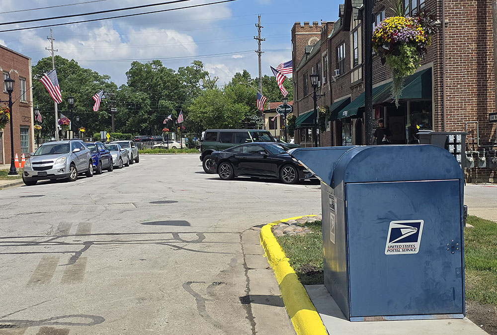 The mailbox that used to be located on the west side of the island in downtown Flossmoor has been relocated to Central Drive. The former location was considered a safety problem because when drivers were depositing mail, other vehicles often veered around on the right, creating potential hazards for pedestrians and other vehicles. (Eric Crump/H-F Chronicle)