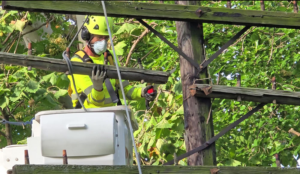 Dave Becker removes a cross arm from one of the three telegraph poles a Flossmoor Public Works crew removed Wednesday, Sept. 10. Several cross arms were given to local historians as artifacts. (Eric Crump/H-F Chronicle)