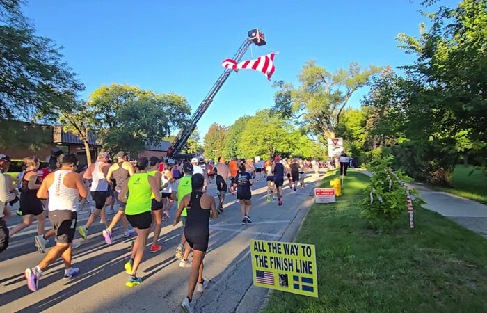 Runners head west on Flossmoor Road past Flossmoor village hall at the start of the Hidden Gem Half Marathon. (Eric Crump/H-F Chronicle)