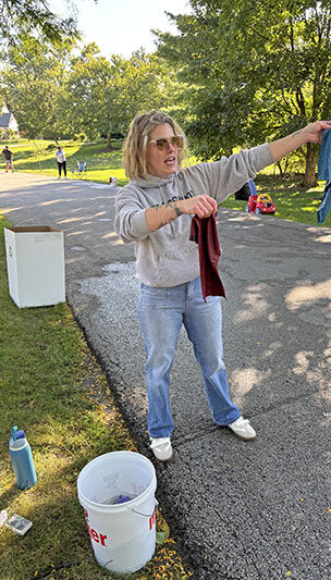 Abby Clausing offered cool, wet rags to give Hidden Gem runners some relief. (Marilyn Thomas/H-F Chronicle)