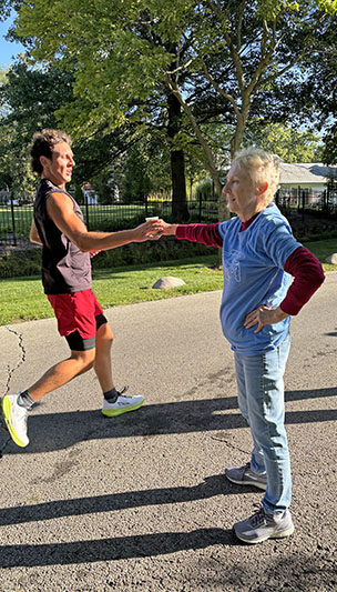 Sharon Jelinck hands off Gatorade to a runner during the Hidden Gem Half Marathon. (Marilyn Thomas/H-F Chronicle)