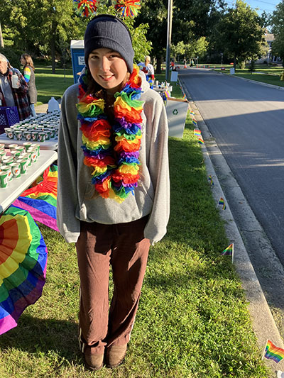 H-F High School freshman Kristell Bricens amid the rainbow decorations in the Flossmoor Park neighborhood during the Hidden Gem Half Marathon. (Randall Weissman/H-F Chronicle)