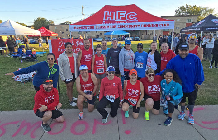 Members of the Homewood-Flossmoor Runners Club pause for a photo during the warm ups before the start of the Hidden Gem Half Marathon. (Eric Crump/H-F Chronicle)