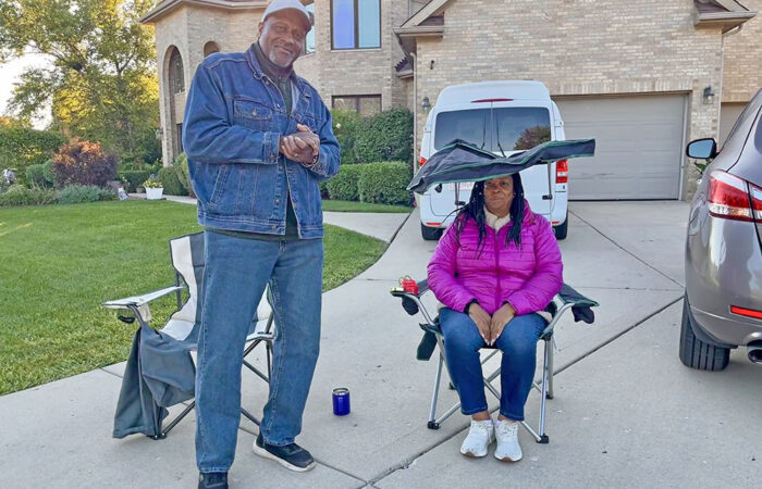 Lafayette and Dina Gatling watch the Hidden Gem Half Marathon from their driveway in Flossmoor. (Nuha Abdessalam/H-F Chronicle)