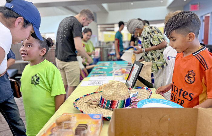 Families gather around the craft tables during Flossmoor Library’s Hispanic Heritage Month celebration. (Nuha Abdessalam/H-F Chronicle)