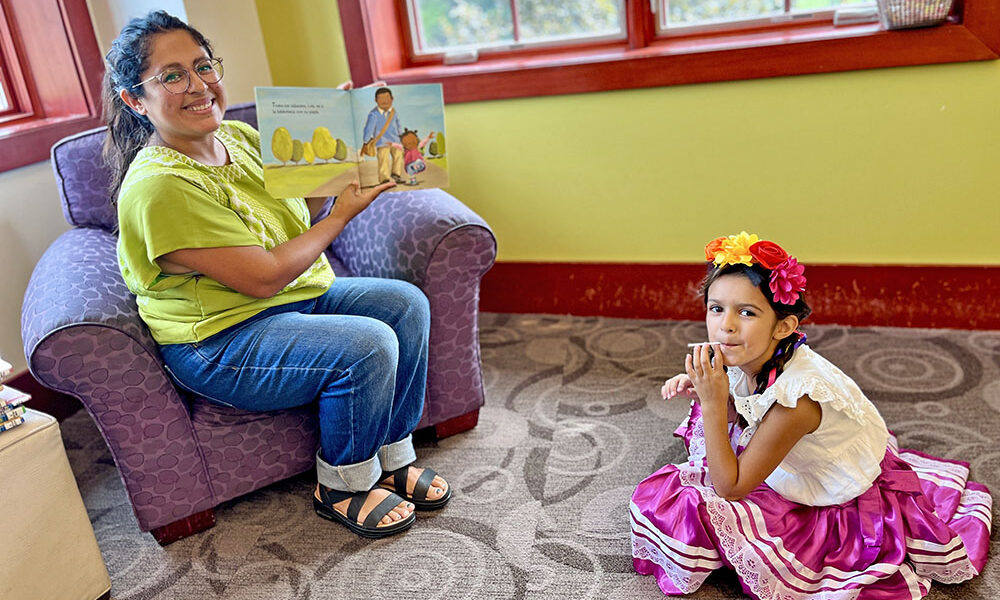 Elena, 6, joins Jessica Cheney for a bilingual story at the library’s first Hispanic Heritage Month event. (Nuha Abdessalam/H-F Chronicle)