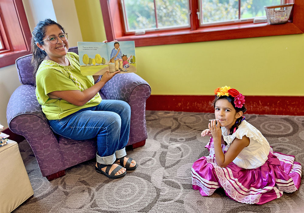 Elena, 6, joins Jessica Cheney for a bilingual story at the library’s first Hispanic Heritage Month event. (Nuha Abdessalam/H-F Chronicle)