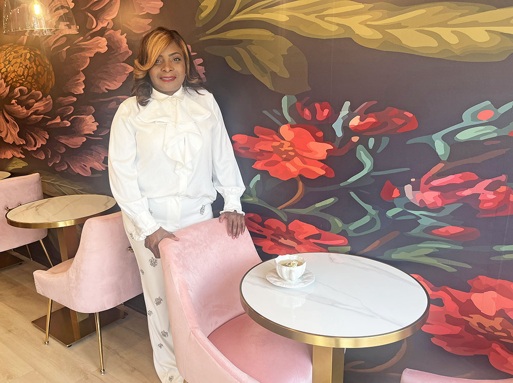 Maison des Fluers owner Lanise Swarn in front the cafe’s wallpaper mural. (Nick Ulanowski)