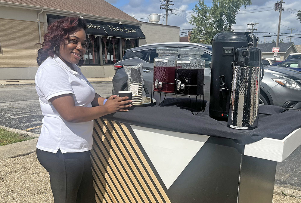 Maison des Fluers server Danielle Bryant, provides free tea samples to passerby on Ridge Road. (Nick Ulanowski / H-F Chronicle)