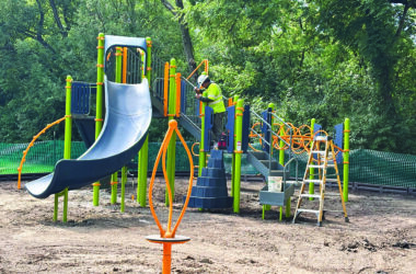 A workman tightens a bolt on the new playground equipment installed at Pheasant Trails Park the week of Aug. 4. (Marilyn Thomas/H-F Chronicle)