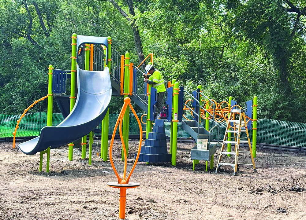 A workman tightens a bolt on the new playground equipment installed at Pheasant Trails Park the week of Aug. 4. (Marilyn Thomas/H-F Chronicle)