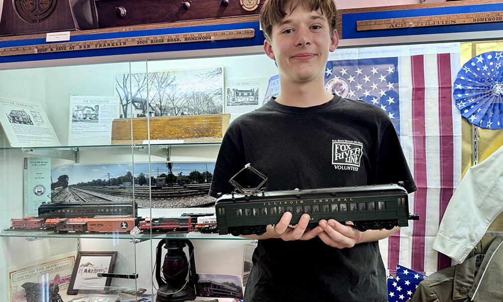 H-F High School sophomore and railroad aficionado Anderson Pries shows off a model of an Illinois Central Railroad (IC) electric passenger car, which currently is displayed with other railroad memorabilia at the Homewood Historical Society museum in the Christian Dorband-Charles Albee Howe building. Anderson is curating a redesigned and expanded Illinois Central exhibit for the museum with HHS Director Megan Tipton. (All photos by Karen Torme Olson)