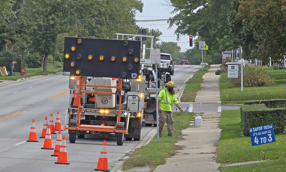 Workers prepare to install a new speed monitoring beacon Oct. 13 on 183rd Street near Gladville Avenue. (Eric Crump/H-F Chronicle)