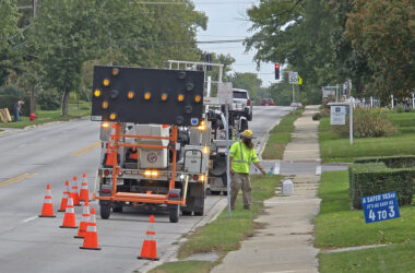 Workers prepare to install a new speed monitoring beacon Oct. 13 on 183rd Street near Gladville Avenue. (Eric Crump/H-F Chronicle)