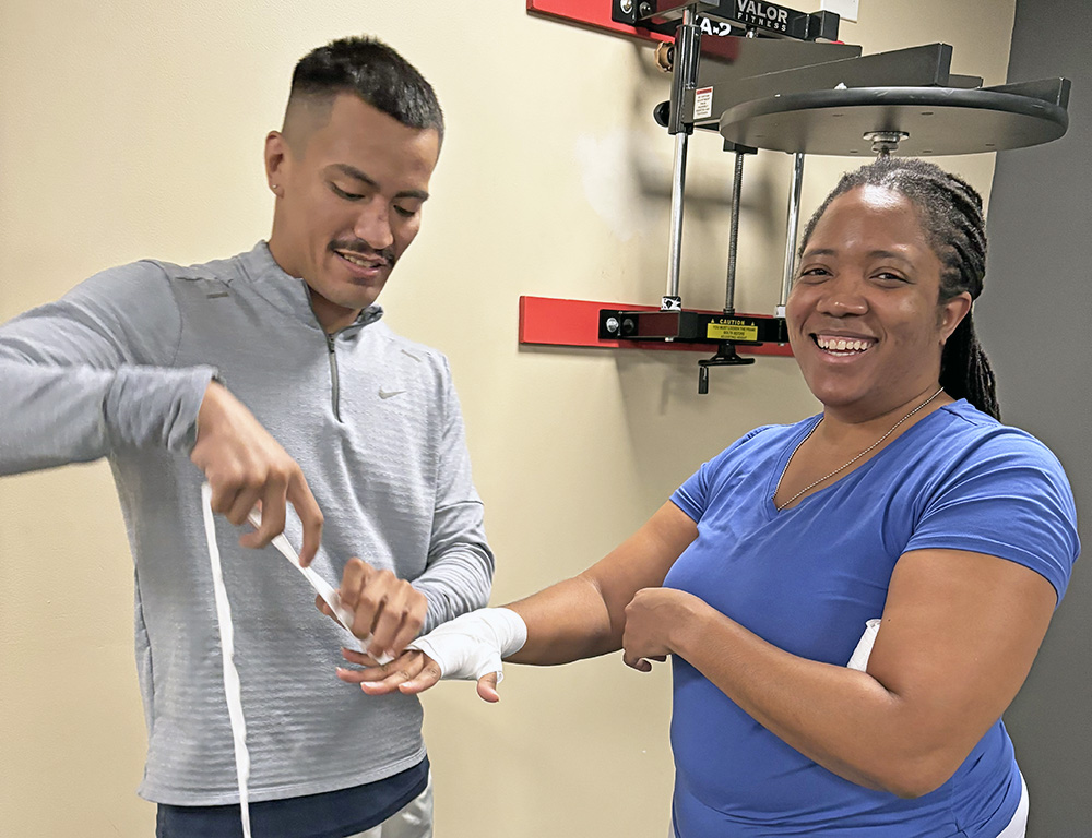 Jennie Ingram of Homewood gets an assist from coach Luis Unzueta on how to properly wrap your hands before boxing. (Marilyn Thomas/H-F Chronicle)