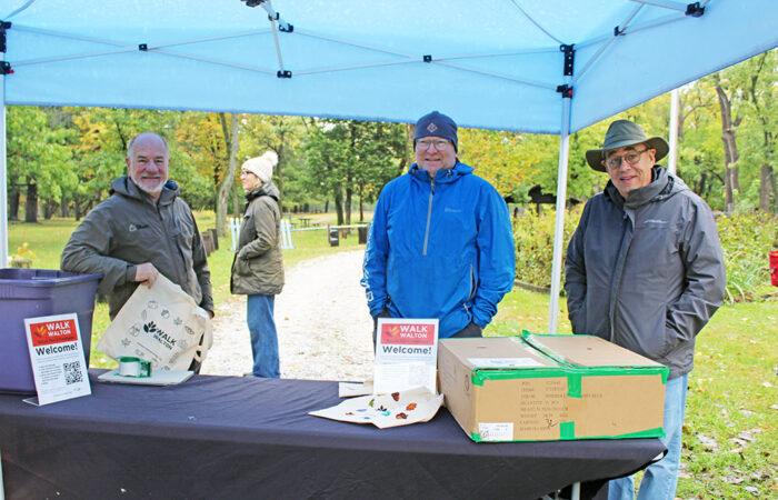 From left, Tom Dobrez, Jeff McClain and Jay Heiferman of the Homewood Science Center greet visitors under the welcome tent during Walk Walton on Sunday, Oct. 19, at Izaak Walton Preserve. (Nuha Abdessalam/H-F Chronicle)