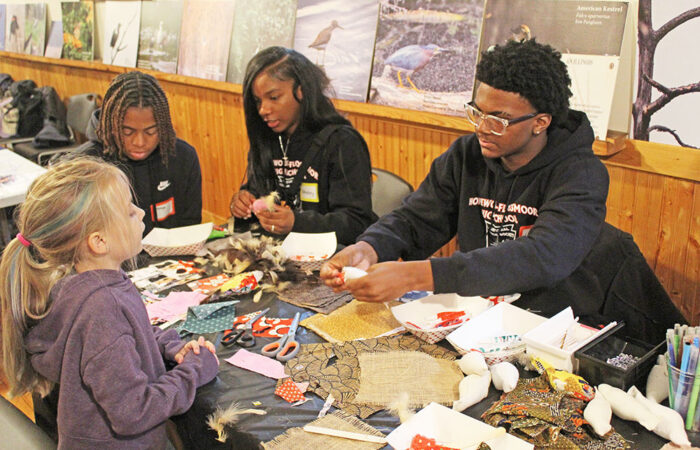 Lee Watkins III explains how reflective decals on windows can save birds' lives as Charlotte Fitch looks on. The H-F High students were part of a group raising awareness about bird safety. (Nuha Abdessalam/H-F Chronicle)