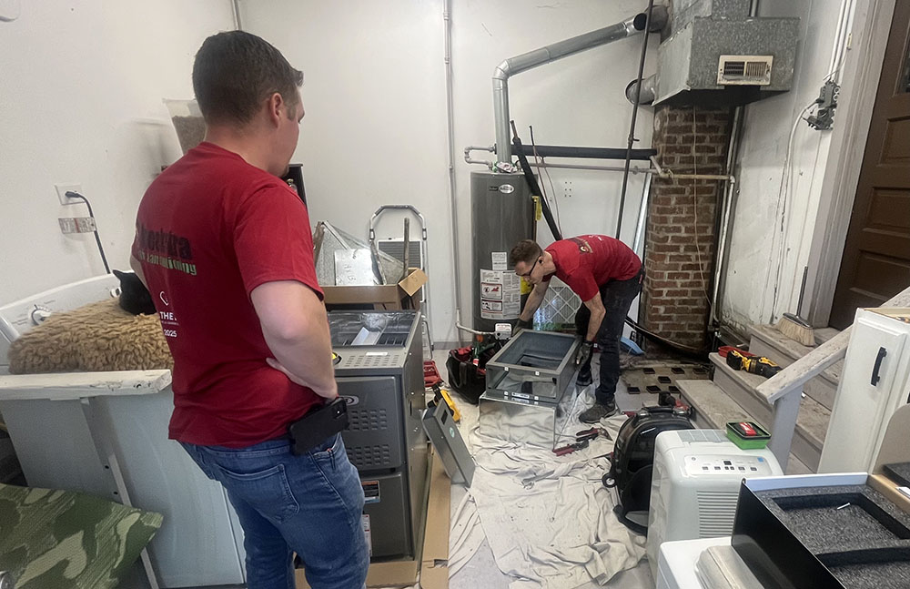 Hoekstra HVAC Field Supervisor Tim Hall, left, and Lead Installer Chris Bartlett install a furnace and air conditioning unit inside Homewood resident Jessica Gadomski’s home for free as a part of Lennox’s nationwide Feel the Love campaign. (Nick Ulanowski/H-F Chronicle)