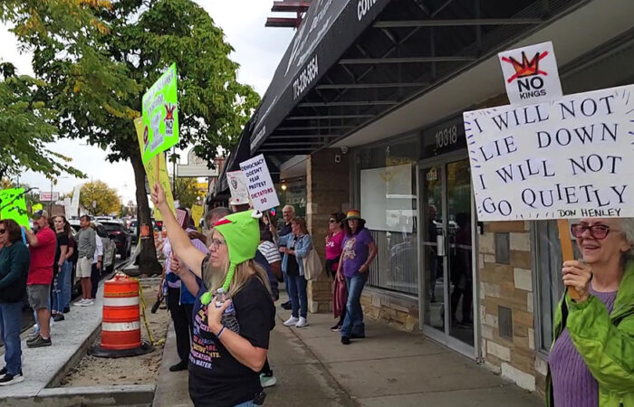 Protesters on the west side of Western Avenue in Beverly hold signs as rain begins during the No Kings rally on Oct. 18. (Eric Crump/H-F Chronicle)