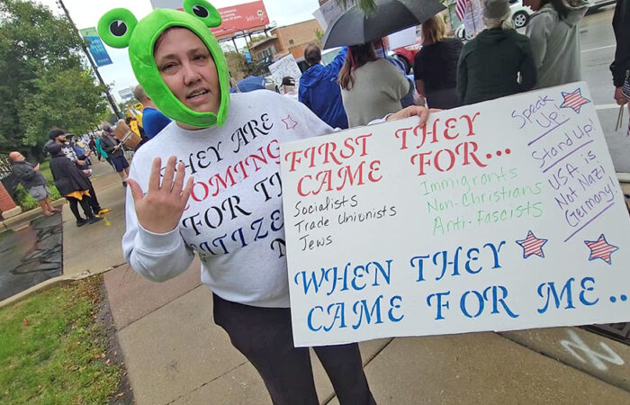 Erica Barton shows her sign, inspired by a famous anti-Nazi poem by Martin Niemöller. (Eric Crump/H-F Chronicle)