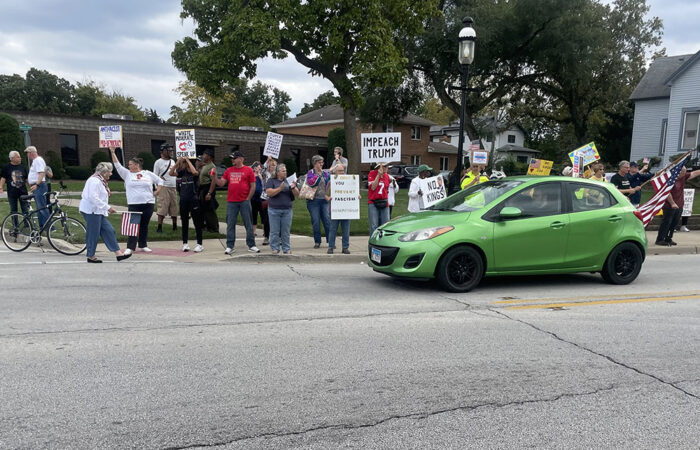Protesters chant as cars go by during No Kings protest Oct. 18 in Homewood. (Jamilah Lewis/H-F Chronicle)