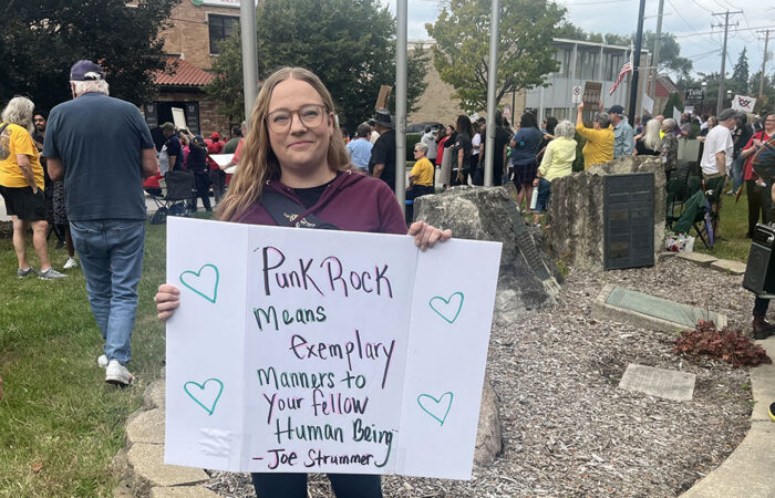 Chicago Heights resident Valarie Jennett holds a sign with a message from punk rock legend Joe Strummer of The Clash. (Nick Ulanowski / H-F Chronicle)