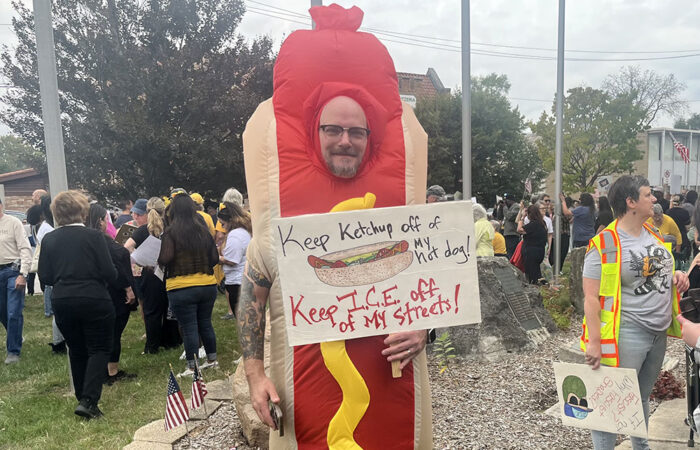 Homewood resident Jon Cook sports a hot dog costume and a sign that reads, "Keep ketchup off of my hot dog! Keep I.C.E. of my streets." (Nick Ulanowski / H-F Chronicle)