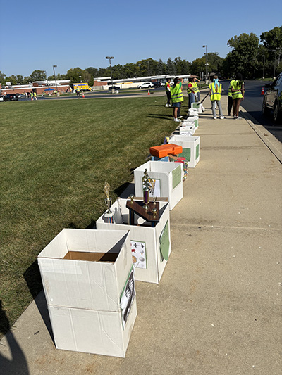 A row of boxes serve as drop-off spots for small items at Recyclepalooza, including trophies, bread tabs, Legos and more. (Marilyn Thomas/H-F Chronicle)