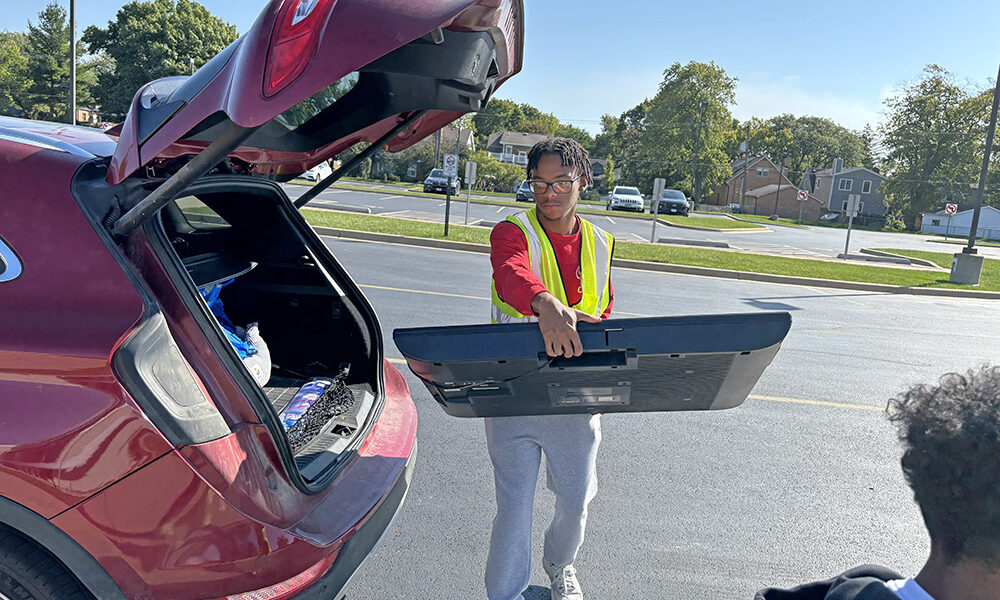 Isaiah Cole, a member of the Homewood-Flossmoor High Key Club, takes a TV for collection during Flossmoor's Recyclepalooza event Sept. 27. (Marilyn Thomas/H-F Chronicle)
