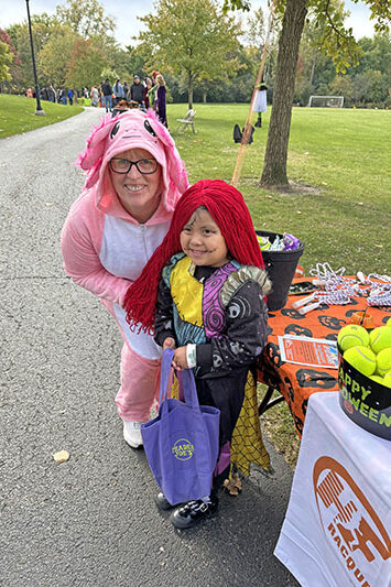 H-F Racquet & Fitness Club staffer Brenda Feehery dons a costume for the Trick or Treat Trail event. She welcomed Ameera Salgado, 4, of Flossmoor. (Marilyn Thomas/H-F Chronicle)
