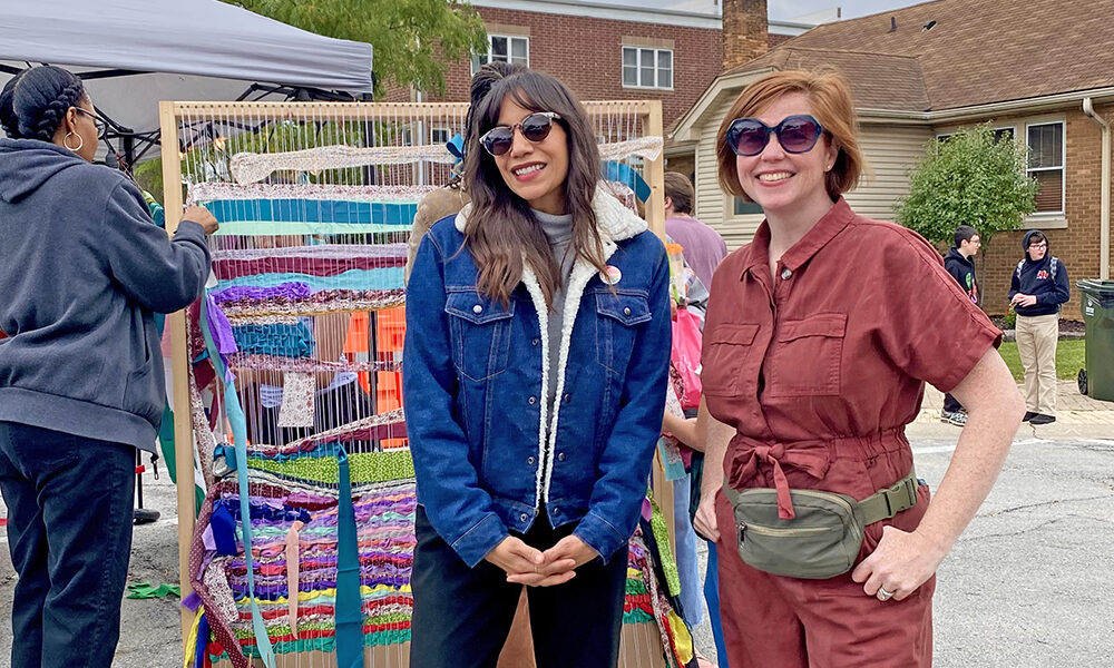 Jessica Matushek and Karlie Sherman of the Homewood Creative Alliance take a break during Fall Fest. The group hosted its first community art project, a day of weaving on a giant loom for festival goers. (Provided photo)