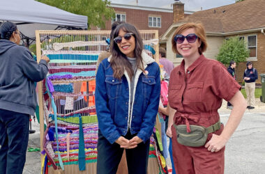 Jessica Matushek and Karlie Sherman of the Homewood Creative Alliance take a break during Fall Fest. The group hosted its first community art project, a day of weaving on a giant loom for festival goers. (Provided photo)