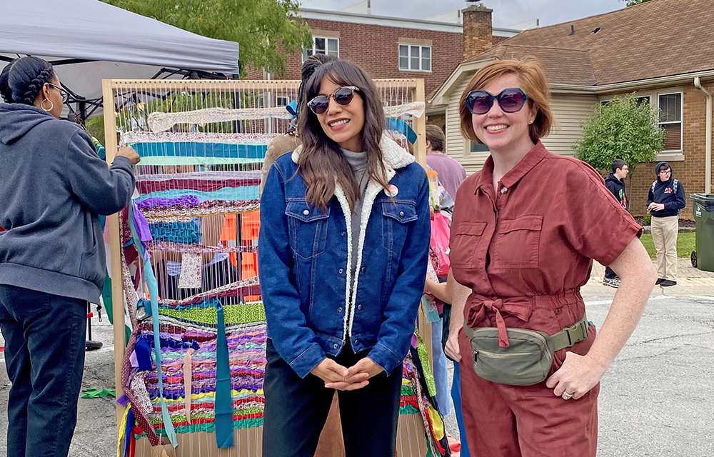 Jessica Matushek and Karlie Sherman of the Homewood Creative Alliance take a break during Fall Fest. The group hosted its first community art project, a day of weaving on a giant loom for festival goers. (Provided photo)