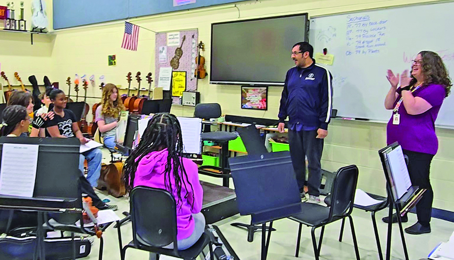 James Hart Orchestra Director Sara White, right, claps as Homewood Arts Council Director Chris Castaneda announces his organization obtained a grant that will pay for the orchestra to take a field trip to a professional recording studio in Chicago. (Eric Crump/H-F Chronicle}