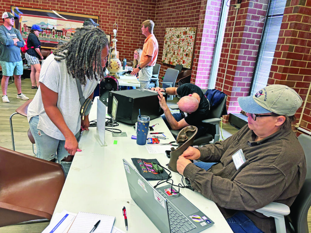 Dominica McBride, standing, watches as Julie Baker takes apart a fountain statue to determine why it wasn't pumping water. The two were part of Chicago Southland Green Committee's Repair Café in Flossmoor, designed to help residents keep household items going longer, keeping them out of landfills. (Marilyn Thomas/H-F Chronicle)