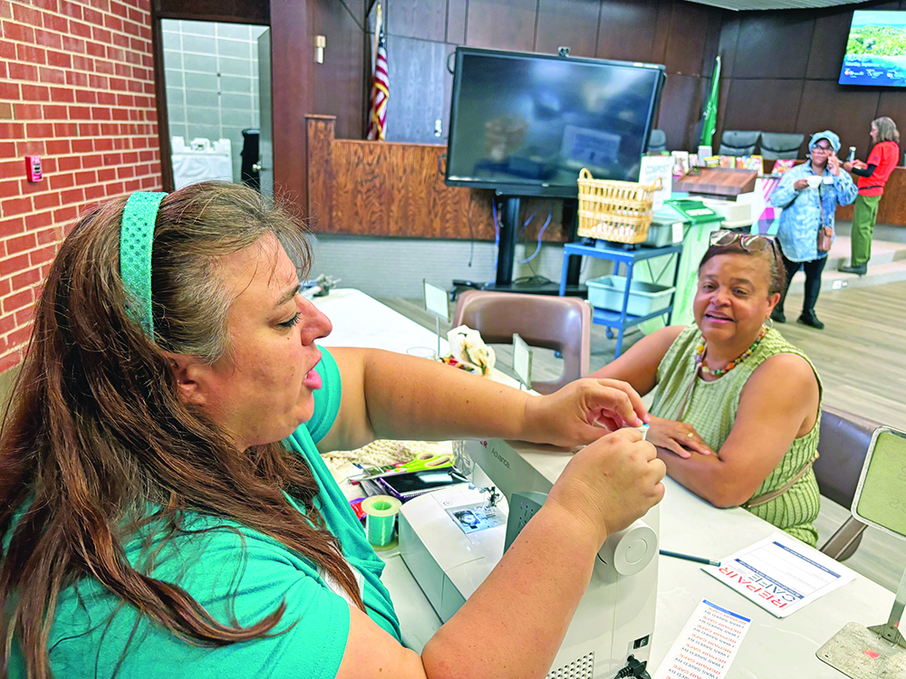 Jewel Jackson, right, thought she'd be discarding her sweater, but Joanna Tassin was able to make a mend at the Repair Cafe. (Marilyn Thomas photos/H-F Chronicle)