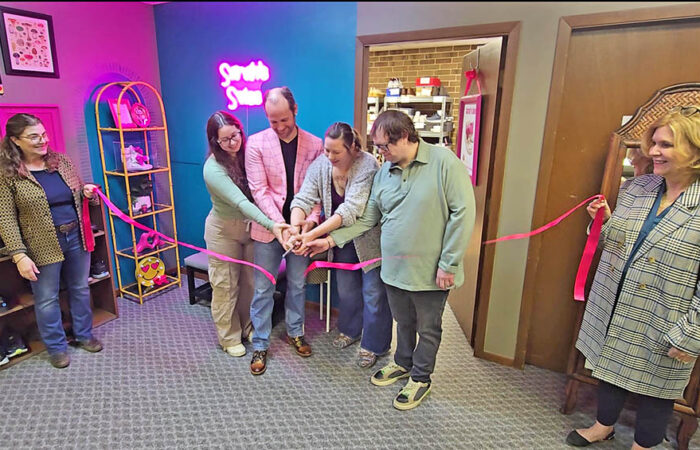 Kristen Ryan, center, and her family cut the ribbon on March 26 to mark the opening of Sarah's Soles, named after Kristen's late daughter. Dodi Wians, left, and Geni Cutler, right, of Suburban Access hold the ribbon. (Eric Crump/H-F Chronicle)