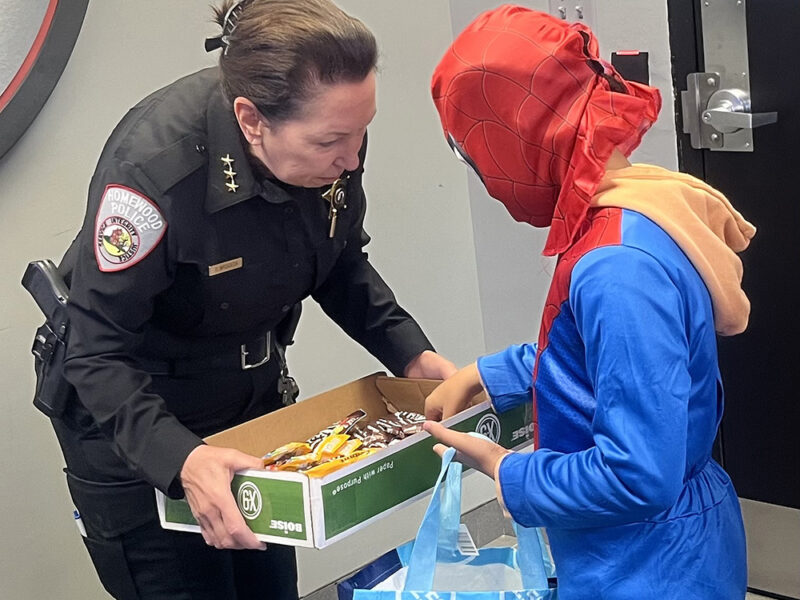 Homewood Police Chief Denise McGrath, left, gives candy to Homewood resident Kaleb Fox. (Nick Ulanowski / H-F Chronicle)