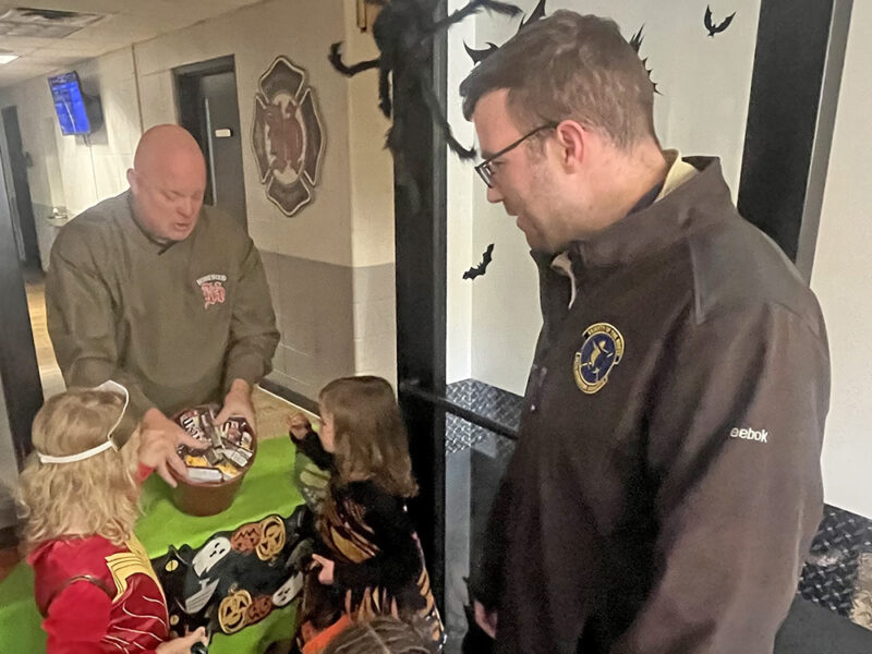 Homewood resident David Conover, right, and his daughters, Arya Conover and Lyla Conover, get candy at the Homewood Fire Department from Homewood Fire Chief Bob Grabowski. (Nick Ulanowski / H-F Chronicle)