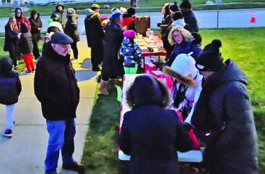 FSL members, right, sell luminaries at the 2024 Flossmoor tree lighting event. (Chronicle file photo)