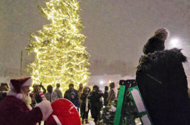 Santa pulls the lever to turn on the lights on the Flossmoor community Christmas tree at the village's holiday celebration on Nov. 29. (Eric Crump/H-F Chronicle)