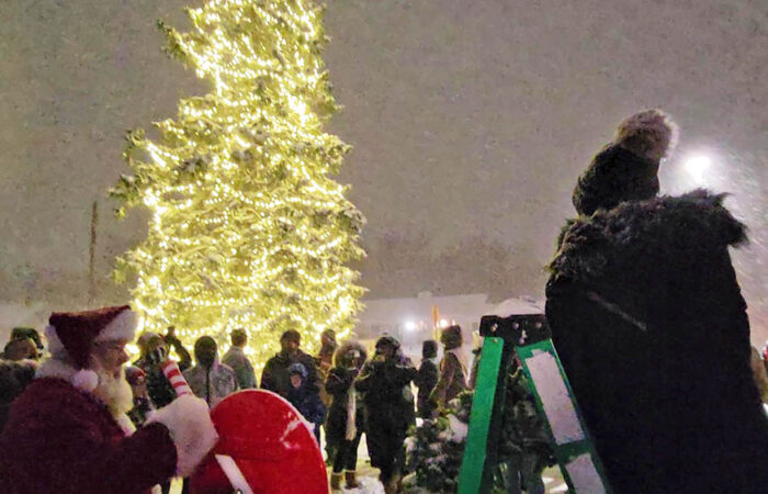 Santa pulls the lever to turn on the lights on the Flossmoor community Christmas tree at the village's holiday celebration on Nov. 29. (Eric Crump/H-F Chronicle)