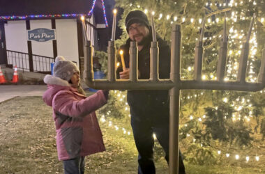 Jacob Schoeneman lights the Flossmoor menorah with help from his 7-year-old daughter, Holly Schoeneman, on Dec. 19, the sixth night of Hanukkah. (Nick Ulanowski / H-F Chronicle)(Nick Ulanowski / H-F Chronicle)